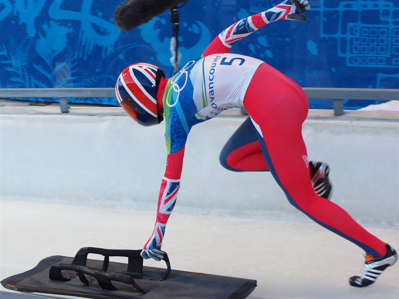 Départ de skeleton, athlète poussant sa luge